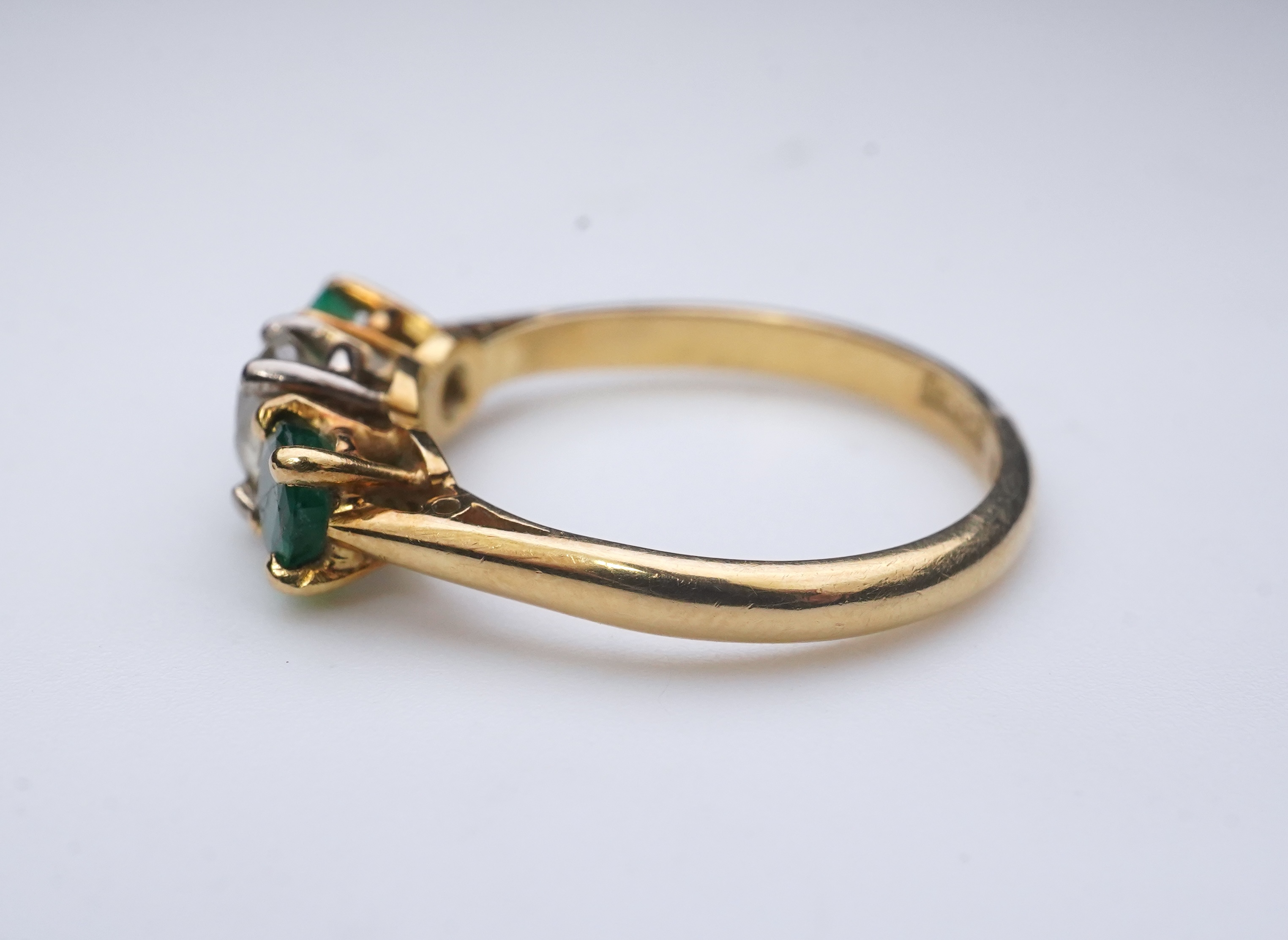 An emerald and diamond three-stone ring